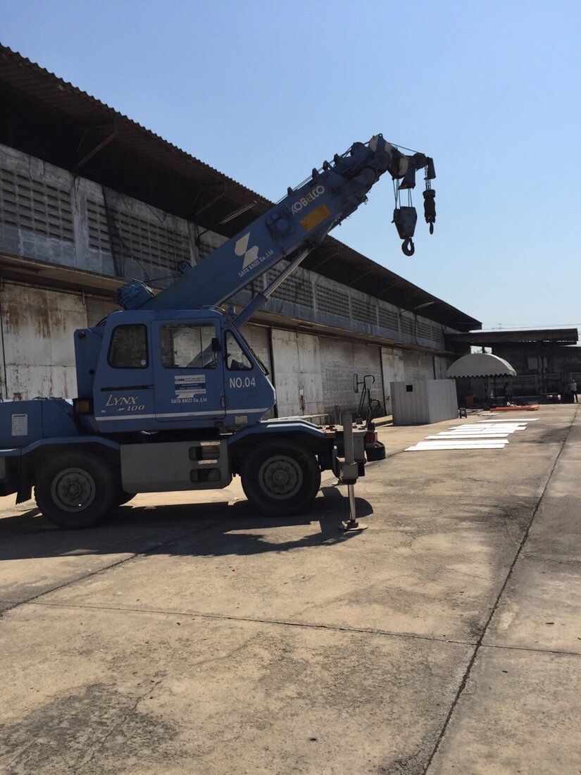 เครนขนาดเล็กของ BIG MACHINE TRADING จอดอยู่หน้าโกดังที่ใช้เป็นสถานที่ถ่ายทำโฆษณาเครื่องดื่มเกลือแร่