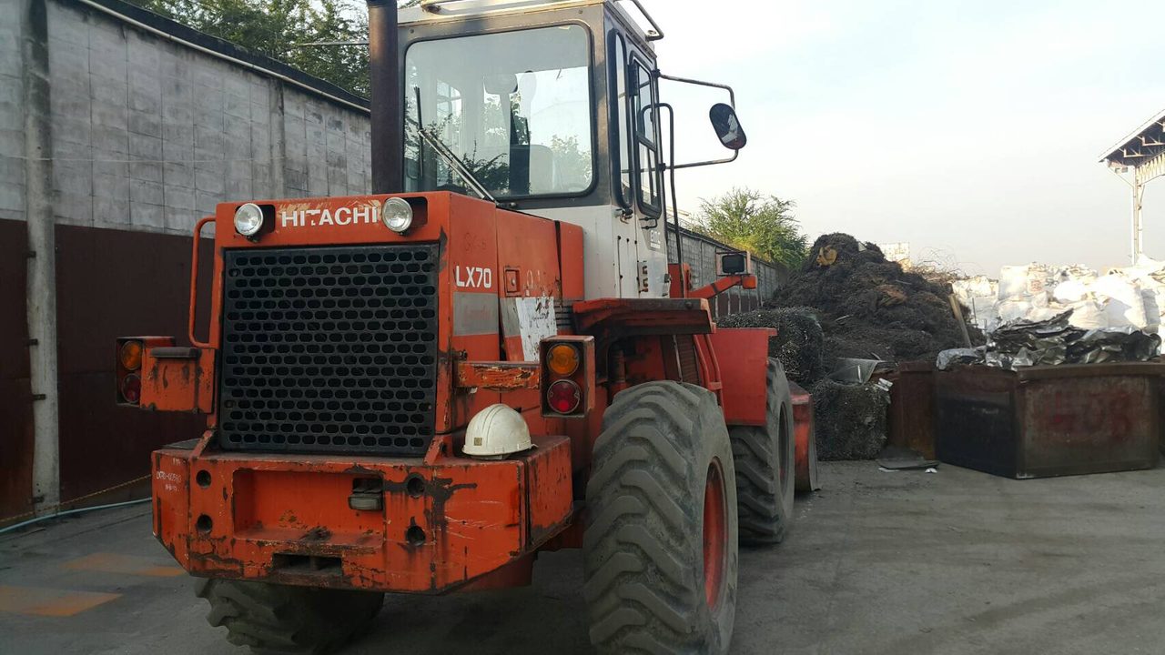 ป้ายหน้ารถตักล้อยาง HITACHI LX70 ของ BIG MACHINE TRADING พร้อมหมวกนิรภัยวางที่กันชนหน้ารถ