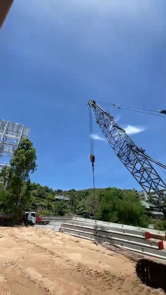 เครนตีนตะขาบ 55 ตันของ BIG MACHINE TRADING หย่อนตะขอเตรียมยกเสาจากกองวัสดุ หน้างานอ่าวอุดม