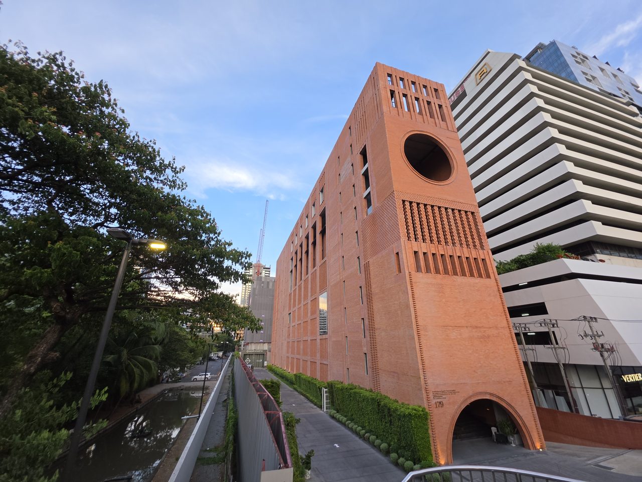 อาคารสถาบันสอนภาษา AUA สาขาราชดำริห์ ที่ก่อสร้างเสร็จสมบูรณ์แล้ว ผนังอิฐแดง 1.7 ล้านก้อน พร้อมช่องเปิดวงกลมขนาดใหญ่