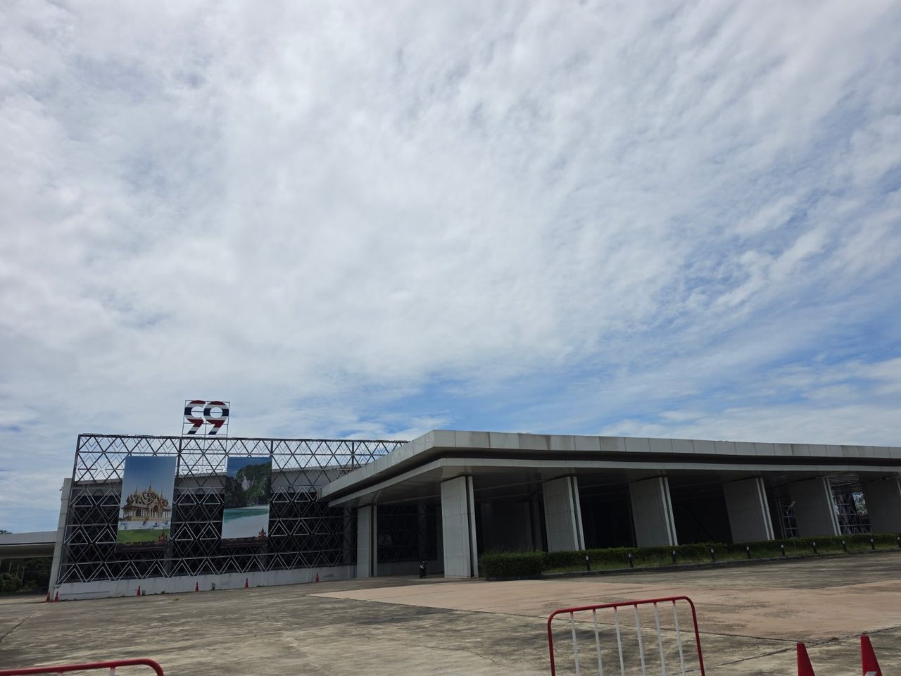 อาคารแสดงสินค้าสำหรับนักท่องเที่ยวที่ก่อสร้างเสร็จสมบูรณ์แล้ว ริมถนนบายพาสชลบุรี มีป้ายตัวเลข 99 และภาพสถานที่ท่องเที่ยวไทยประดับด้านหน้าอาคาร