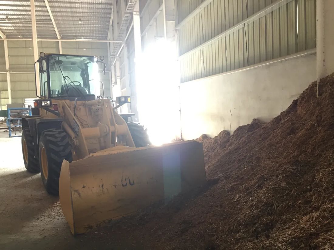 รถตักล้อยาง BIG MACHINE TRADING ใช้บุ้งกี๋ดันกองไม้สับชิดผนังโกดัง นิคมเกตเวย์ ซิตี้