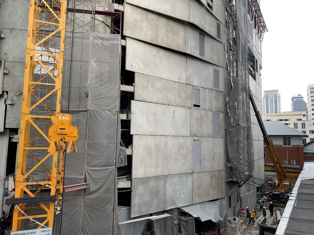 ผนังคอนกรีตสำเร็จรูปด้านนอกอาคาร IDEO Q Victory คอนโด High Rise พร้อมทาวเวอร์เครนและเครนล้อยาง BIG MACHINE TRADING ทำงานอยู่ด้านล่าง