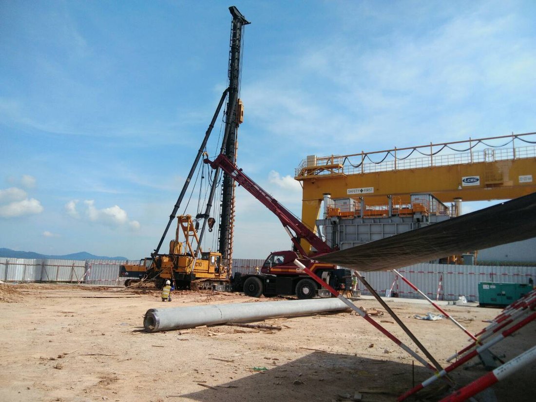มุมกว้างหน้างานเสาเข็มคอนกรีตสปัน มีเครนล้อยาง BIG MACHINE TRADING ทำงานร่วมกับปั้นจั่นตอกเสาเข็มตีนตะขาบ ที่หน้างานโกดัง KONOIKE Cool Logistics บางพลี