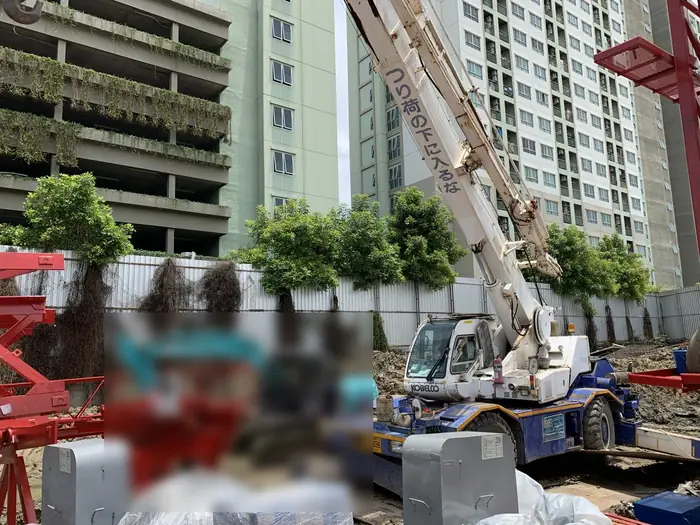 เครน BIG MACHINE TRADING เห็นตัวรถเต็มคัน ทำงานก่อสร้างอาคารสูงคอนโดมิเนียม