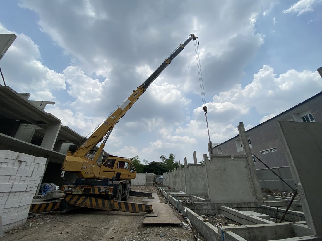 เครนล้อยาง Crevo 250 ของ BIG MACHINE TRADING ทำงานใกล้ผนังพรีคาสท์และกองแผ่นโฟมฉนวนหน้างาน