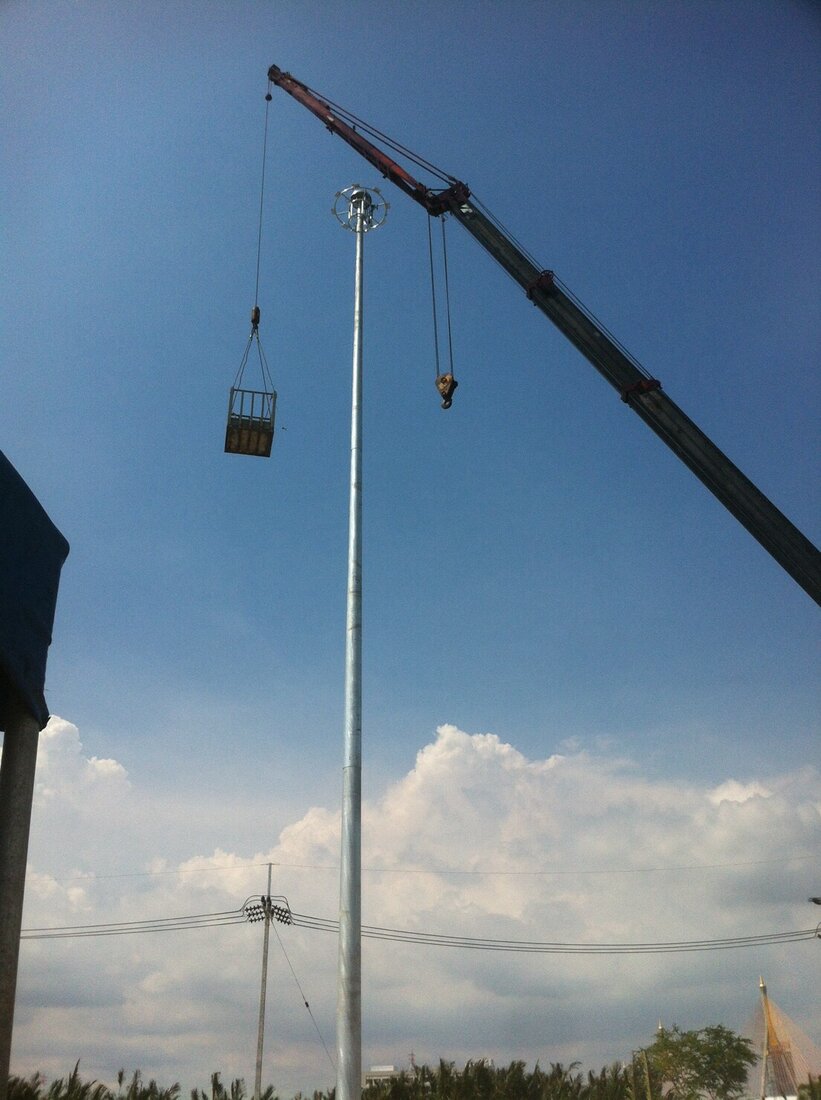 กระเช้ายกคนของ BIG MACHINE TRADING ถูกยกขึ้นข้างเสาไฟสูงที่ติดตั้งเสร็จแล้วที่สวนสาธารณะปู่เจ้าสมิงพราย