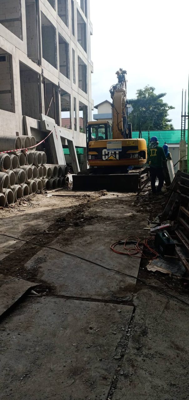 รถขุดตีนตะขาบ CAT 313B ของ BIG MACHINE TRADING จอดพร้อมทำงานหน้าไซต์ก่อสร้าง มีทีมงานยืนตรวจสอบความพร้อม