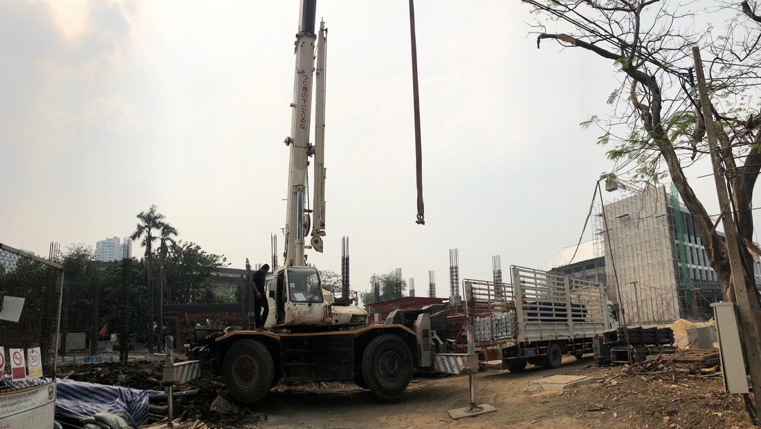 เครนล้อยาง 25 ตัน 4 ล้อ TADANO ของ BIG MACHINE TRADING ยืดบูมพร้อมสลิงยกของ หน้างานก่อสร้างอาคารภาครัฐ ย่านเชิงสะพานพระราม 7