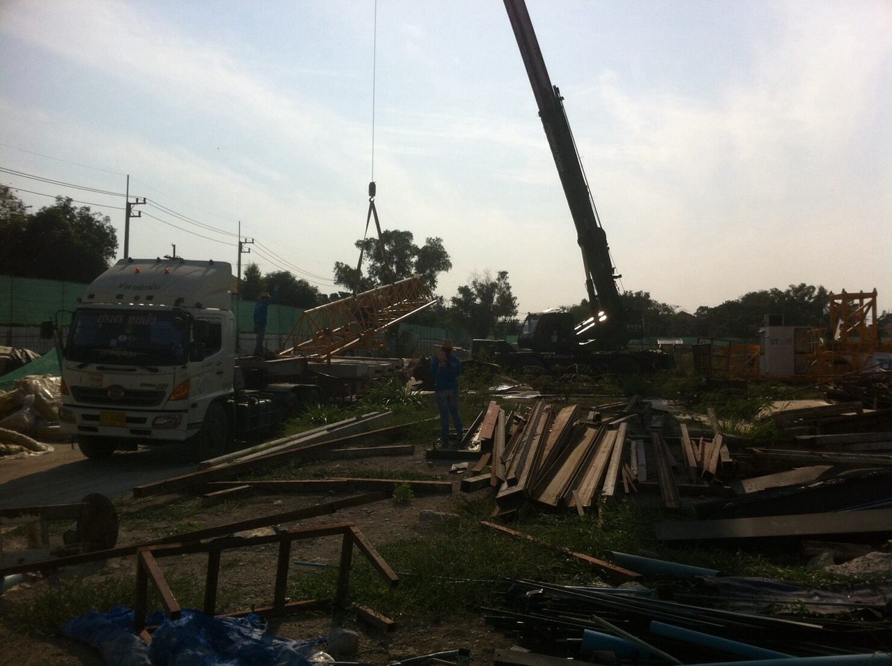 เครนล้อยางยกโครงเหล็ก Tower Crane สีเหลืองที่ไซต์งานรังสิต