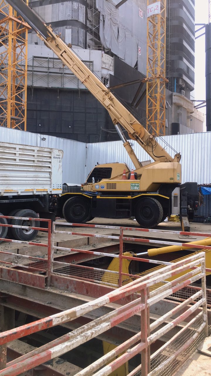 เครนล้อยาง KATO ของ BIG MACHINE TRADING ทำงานใกล้เครนหอสูงในไซต์ก่อสร้างอาคารสูงย่านสุขุมวิท 36