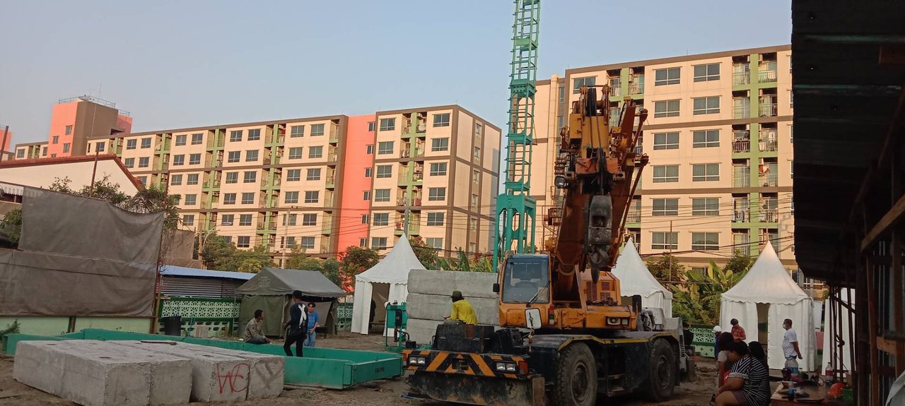เครนล้อยาง 25 ตันของ BIG MACHINE TRADING ทำงานหน้าไซต์ทดสอบเสาเข็ม เห็นอาคารที่พักอาศัยเป็นฉากหลัง ย่านสุขุมวิท 76