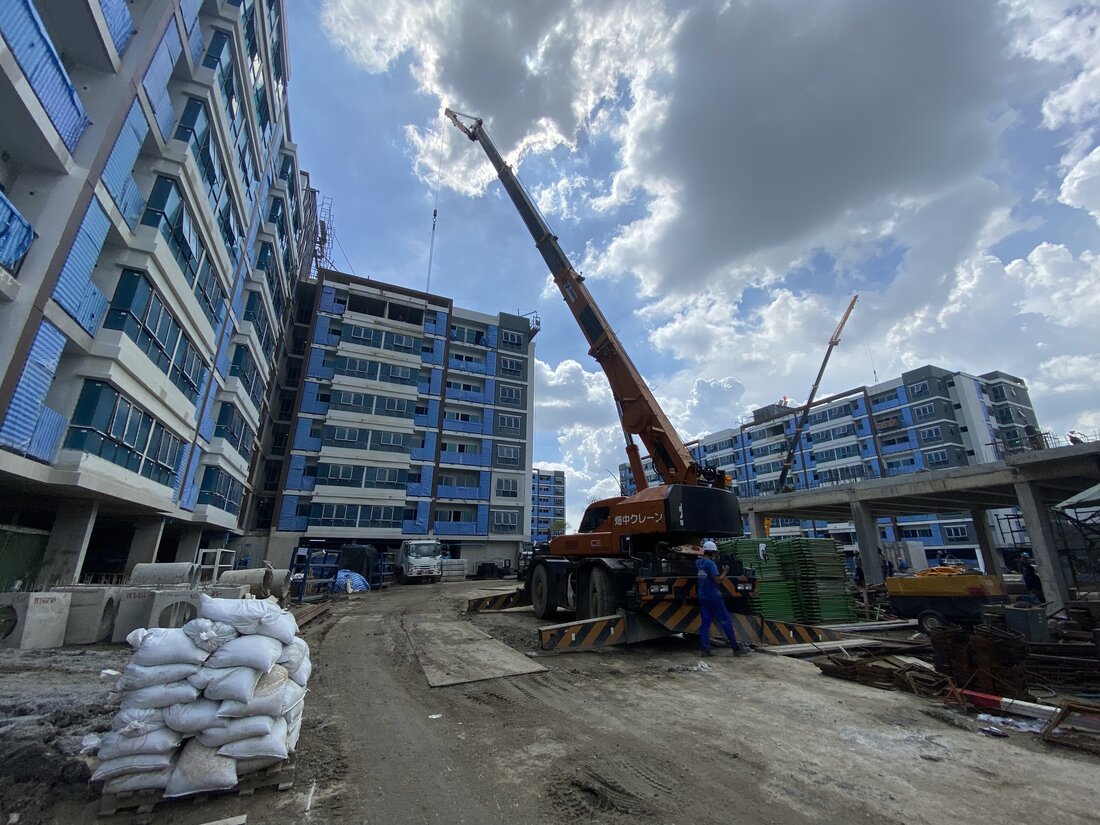 เครนล้อยาง BIG MACHINE TRADING ทำงานท่ามกลางอาคารคอนโดที่สร้างเสร็จโครงสร้างแล้วที่ศุภาลัย ซิตี้ รีสอร์ท สุขุมวิท 107