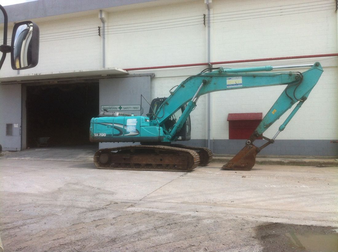 แบคโฮ KOBELCO SK200 ของ BIG MACHINE TRADING จอดหน้าอาคารโกดังในโรงงานอุตสาหกรรมวิวัฒน์ อยุธยา