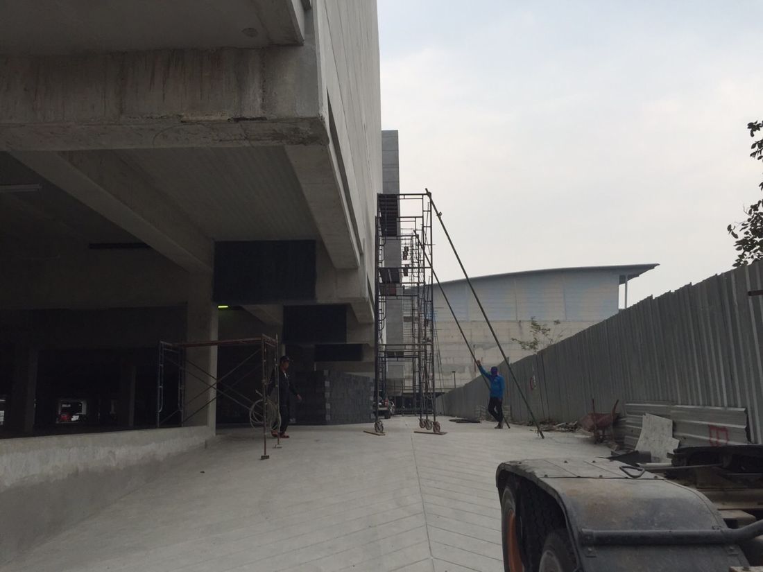 ช่างและนั่งร้านเคลื่อนที่ทำงานช่วงล่างของอาคารสตูดิโอ Workpoint ปทุมธานี